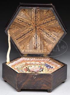 an old wooden box with many different items in it's lid and inside compartments