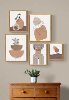 four framed art pieces hang on the wall above a dresser with a potted plant