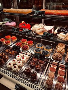 a display case filled with lots of different types of cakes and pastries in it