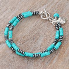 Thailand's Tipa works with reconstituted turquoise and hematite stones to handcraft a stylish design for any occasion. This two-strand bracelet has a trendy style thanks to its intense colors and striking beads. On top of that, a silver hill tribe charm brings a sweet touch to the item. Handmade Turquoise Multi-strand Bracelets, Adjustable Turquoise Hand-strung Beaded Bracelets, Adjustable Hand-strung Turquoise Beaded Bracelets, Adjustable Ocean-inspired Turquoise Beaded Bracelets, Turquoise Hand-wrapped Hippie Beaded Bracelets, Rose Quartz Bracelet Beads, Hematite Jewelry, Cultured Pearl Bracelet, Trending Bracelets