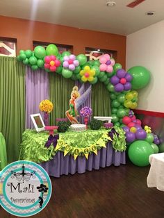 a table with balloons and decorations in the shape of tinkerbells on it