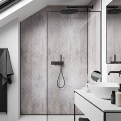 a bathroom with a walk in shower next to a white sink and black faucet