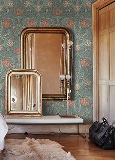 a bedroom with a mirror, vanity and luggage on the floor in front of it