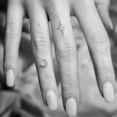 a woman's hand with a star and moon tattoo on it