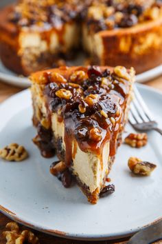 a piece of cheesecake on a plate with pecans around it and a fork