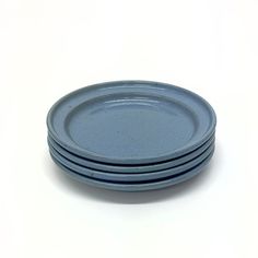 three blue plates stacked on top of each other in front of a white background,