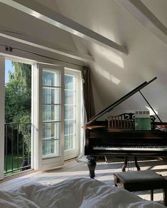 there is a grand piano in the corner of this room, and an open window