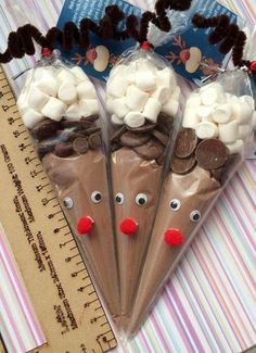 three plastic cones with chocolate and marshmallows in the shape of reindeer faces