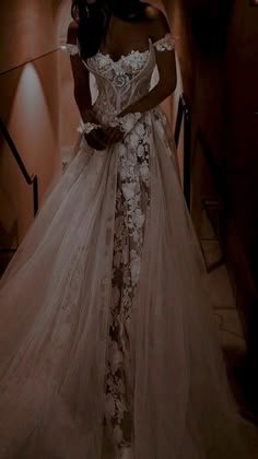 a woman in a wedding dress standing on the stairs