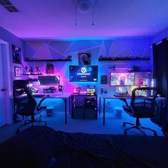 the room is lit up with purple and blue lights, including two computer desks