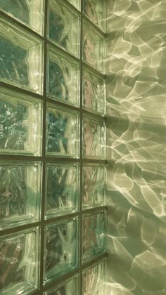 the wall is made up of glass blocks and reflecting water on it's surface