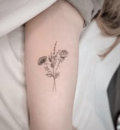 a small flower tattoo on the arm