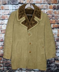 AMAZING VINTAGE CLASSICALLY STYLED RANCHER COAT BY "GREAT WESTERN MINNEAPOLIS" GLENANDES FABRIC BY GLENOIT THIS COAT IS CIRCA 1970'S I BELIEVE?  COULD EVEN BE 60'S? COAT HAS A DURABLE EXTERIOR - SIMILAR TO SUEDE BUT IT IS NOT MADE OF REAL LEATHER FULLY LINED IN A SHERPA STYLE WITH FAUX SHEARLING FUR LINING BEIGE IN COLOR / BROWN LINING 3 BUTTON FRONT PLACKET DOUBLE POINT COLLAR Listed as a Mens Size 402 Total length: 35”  Shoulder width: 19”  Pit to pit: 22”  Shoulder to cuff: 25” NICE VINT Vintage Winter Fur Coat With Faux Fur Lining, Vintage Long Sleeve Fur Coat With Faux Fur Lining, Vintage Long-sleeved Faux Fur Coat, Vintage Brown Outerwear With Faux Fur Trim, Vintage Outerwear With Faux Fur Lining And Long Sleeves, Vintage Fur Coat With Faux Fur Lining For Fall, Vintage Lined Winter Outerwear, Vintage Lined Outerwear For Winter, Vintage Winter Outerwear