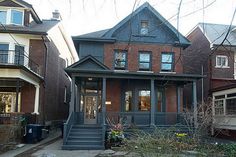 the house is painted blue and has two storys on each side, along with several windows