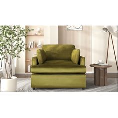 a green chair and ottoman in a living room with a potted plant on the floor