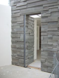 an open door to a room that is made out of wood and concrete blocks with metal bars on each side