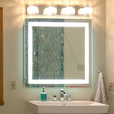 a bathroom sink with a lighted mirror above it