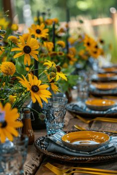 the table is set with sunflowers and plates