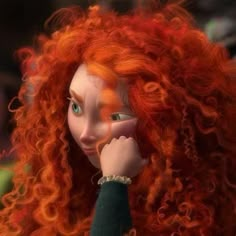 a close up of a doll with long red hair and blue eyes wearing a green shirt