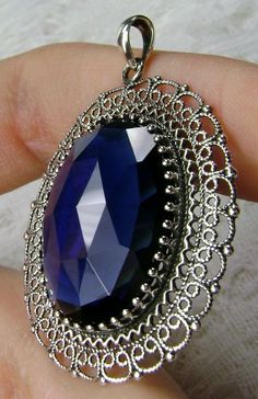 "Simulated Blue Sapphire Pendant Mesh Design#P14 Custom Made Inspired by Victorian era jewelry, I now offer this lovely Antique reproduction in sterling silver. The 20ct simulated blue sapphire gemstone is 24mm long (just shy of 1 inch) and 18mm in width (11/16th\"). The entire pendant is 1 3/4th inches long. The necklace/bail opening is 5mm x 3mm. Notice the beautiful craftsmanship of the Victorian filigree setting. The original antique piece that this pendant was designed from, was a Victorian Victorian Era Jewelry, Victorian Filigree, Victorian Cameo, Clear Crystal Necklace, Stock Design, Blue Sapphire Pendant, Blue Sapphire Gemstone, Filigree Pendant, Gold Jewellery Design Necklaces