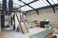 a living room filled with furniture and a wooden staircase leading up to the top floor