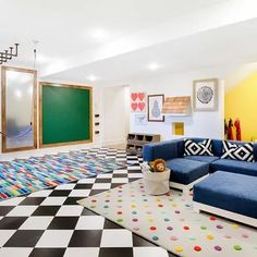 a brightly colored living room with black and white checkered flooring, colorful rugs, yellow walls, and green chalkboard