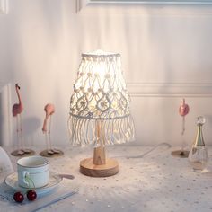 a table topped with a lamp next to a cup and saucer