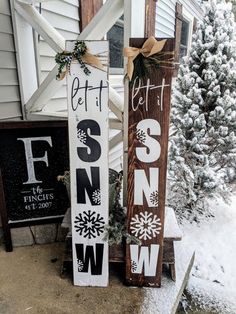 two wooden signs that are sitting in the snow