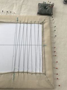 a piece of fabric with pins and needles on it