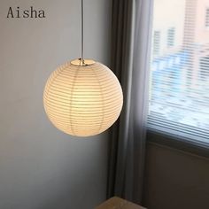 a white lamp hanging from the ceiling next to a window