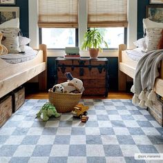 two twin beds in a bedroom with checkered rugs and toys on the floor