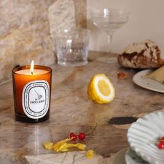 a candle sitting on top of a counter next to plates