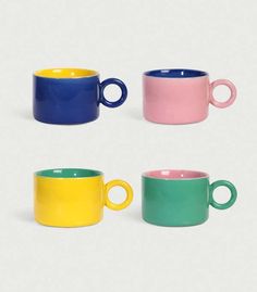 three different colored mugs sitting next to each other