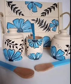 blue and white pottery is displayed on a table with utensils in front of it