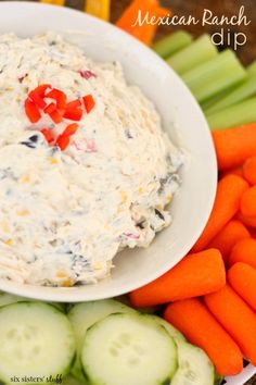 carrots and celery sticks with dip in a white bowl