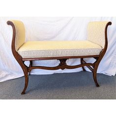 a wooden bench sitting on top of a carpeted floor next to a white wall