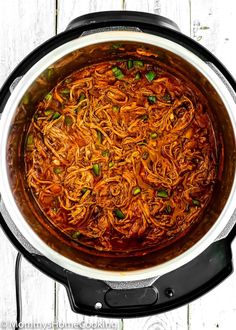 a large pot filled with food on top of a wooden table