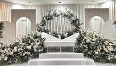 an altar with white flowers and greenery around it