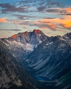 the mountains are covered in snow as the sun is setting over them and there is no image to describe