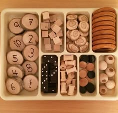 an organized tray with wooden numbers and magnets in it on top of a table