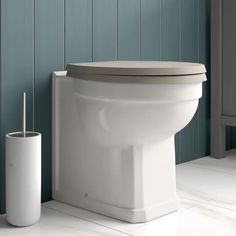 a white toilet sitting on top of a bathroom floor next to a roll of toilet paper