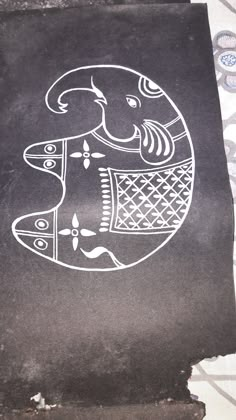 a black piece of paper with an elephant drawn on it