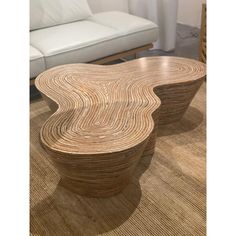 two wooden tables sitting next to each other on top of a carpeted floor in front of a white couch