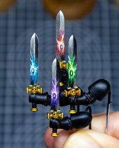 someone is holding some kind of toy with lights on it's fingers and there are four knives in the middle