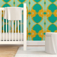 a white crib in front of a green and yellow wallpaper with an abstract design