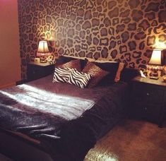 a bedroom with leopard print wallpaper and two lamps on either side of the bed