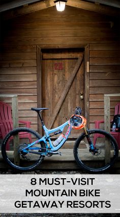 a blue mountain bike parked in front of a wooden building with the words, 8 must - visit mountain bike getaway resort