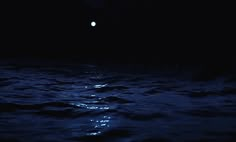 the moon shines brightly in the dark sky over the ocean