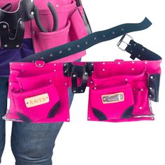 a woman is holding two pink and black purses with one in her pocket, the other in her hand