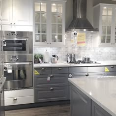 a kitchen with stainless steel appliances and white counter tops